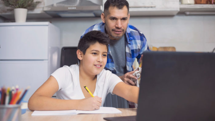 Son showing father work on a computer screen.