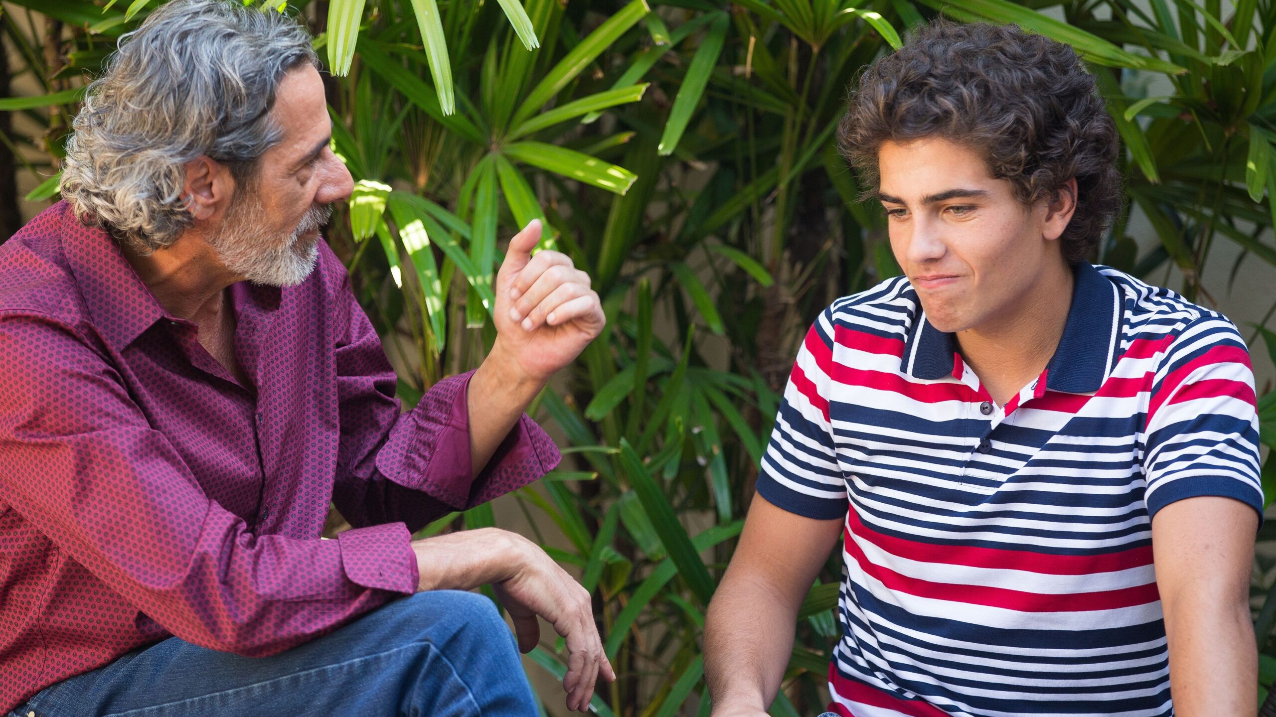 Father and son talking on a bench.